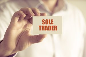man holding business card with the text sole trader on it