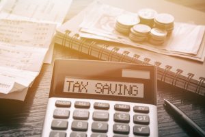 picture of a calculator with the words tax saving written across it, a guide on tax saving strategies